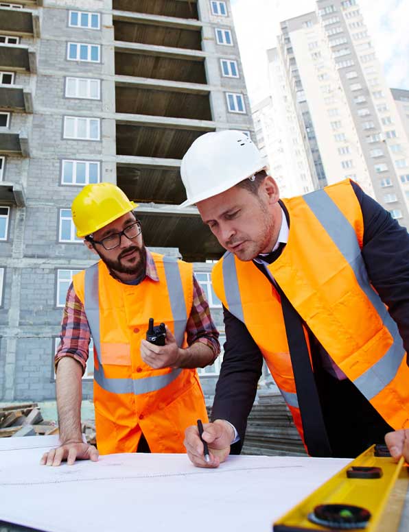 Construction workers discussing design plans and using a two-way radio