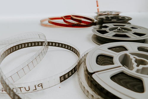 Four film reels unraveling from their spools