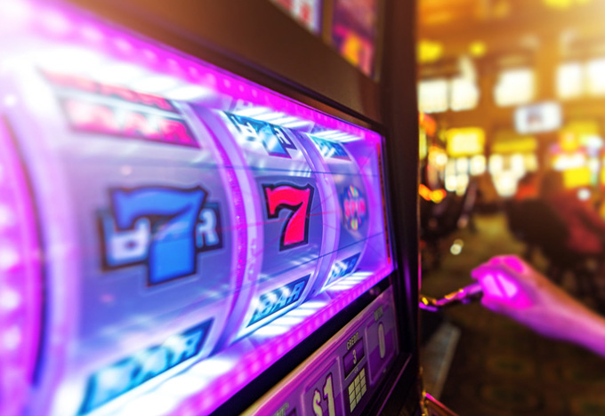 A person operating a slot machine in a casino