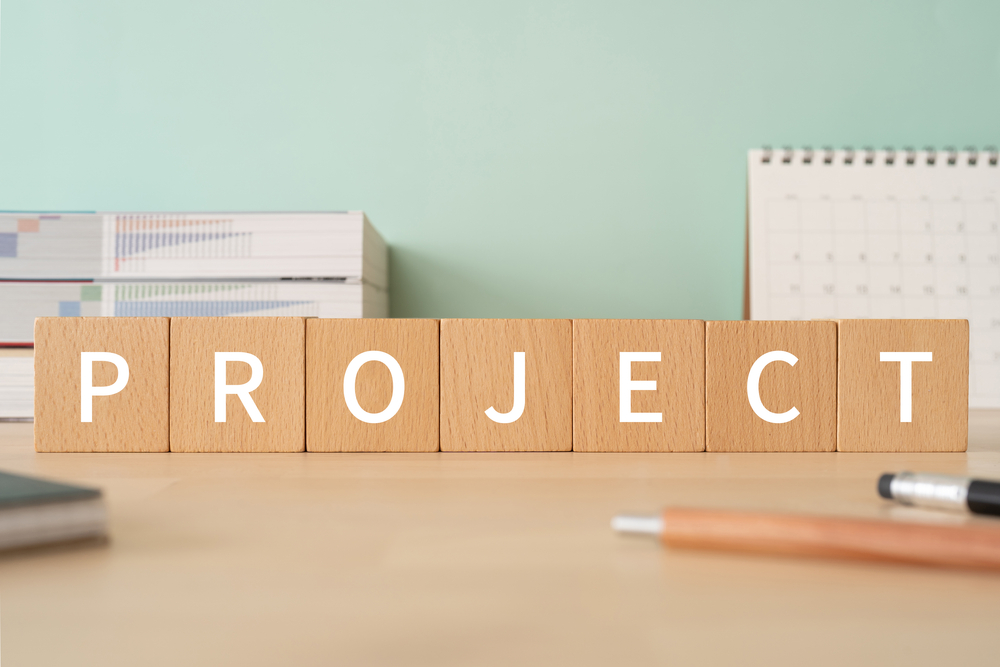 wooden blocks spelling out the word "project" on a desk